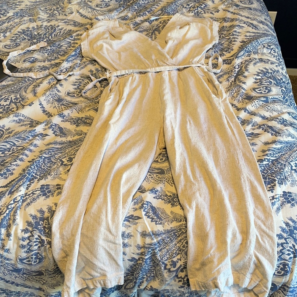 Small tan colored jumpsuit with elastic waist band and belt. Capri length legs.